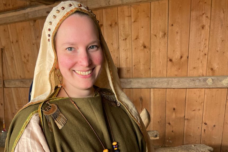 Darstellerin in keltischer Gewandung zeigt historische Handarbeit in einem rekonstruierten Haus der Heuneburg