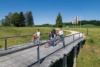 Eine Familie schiebt ihre Räder über die Eingangsbrücke