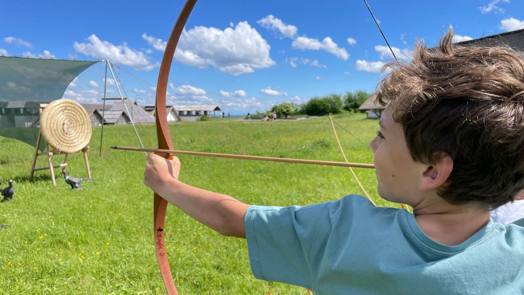 Kind beim Bogenschießen auf einer Wiese der Heuneburg – Stadt Pyrene
